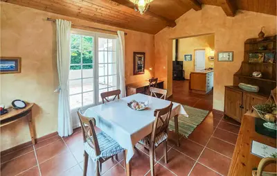 a kitchen and dining room with a white table and chairs at Awesome Home In Ferrières-Poussarou in Ferrières-Poussarou