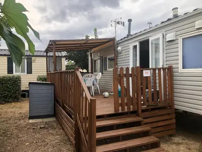 a wooden deck with awning on a house at Cathy & David-Mobile Home 11-Camping Novela in Port-la-Nouvelle