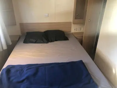 a small bed in a small room with at Cathy & David-Mobile Home 11-Camping Novela in Port-la-Nouvelle