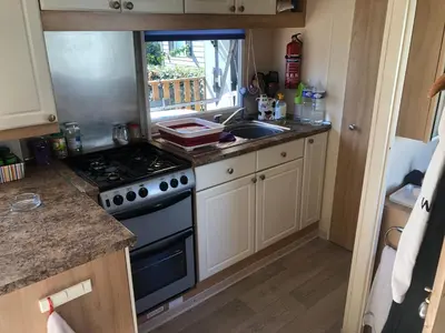 a kitchen with a stove and a sink at Cathy & David-Mobile Home 11-Camping Novela in Port-la-Nouvelle