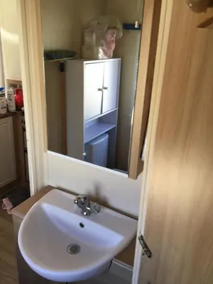 a bathroom with a sink and a mirror at Cathy & David-Mobile Home 11-Camping Novela in Port-la-Nouvelle