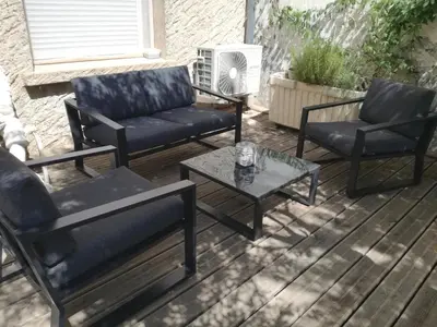 a patio with three chairs and a coffee table at La pause sous le pin B&B Chambres d'hôtes in Capestang