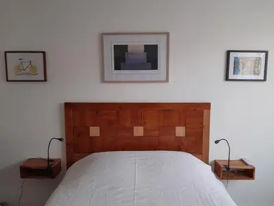 a bedroom with a bed and two pictures on the wall at La pause sous le pin B&B Chambres d'hôtes in Capestang