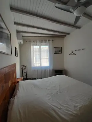 a bedroom with a large bed and a window at La pause sous le pin B&B Chambres d'hôtes in Capestang