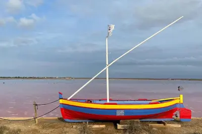 a boat sitting on the shore of a body of water at Superbe appartement rénové avec vue magnifique in Gruissan