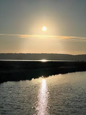 a sun setting over a body of water at Superbe appartement rénové avec vue magnifique in Gruissan