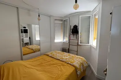 a bedroom with a yellow bed and a mirror at Superbe appartement rénové avec vue magnifique in Gruissan
