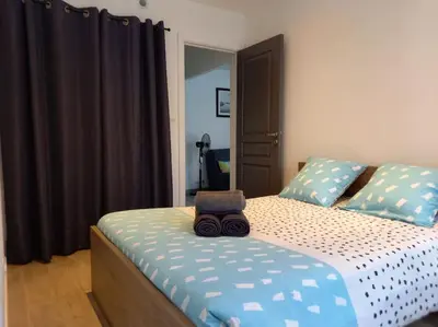 a bed with a bag sitting on top of it at Cosy T2, Meublé de tourisme 3 étoiles, Parking fermé , 2Vélos, Wi-Fi in Narbonne