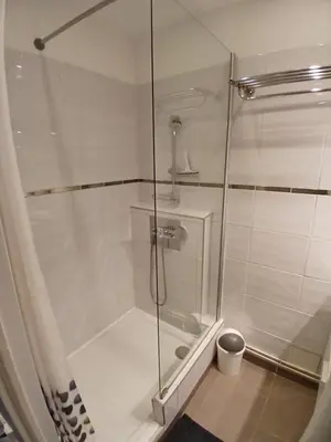 a shower with a glass door in a bathroom at Cosy T2, Meublé de tourisme 3 étoiles, Parking fermé , 2Vélos, Wi-Fi in Narbonne