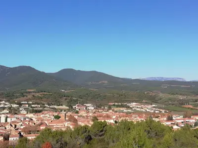 a view of a town with mountains in the background at Chez Mi, centre ville, parking gratuit in Saint-Chinian