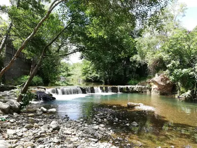 a waterfall in a river with rocks and trees at Chez Mi, centre ville, parking gratuit in Saint-Chinian