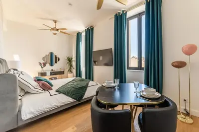 a bedroom with a bed and a table with chairs at The Gatsby room - 50m des halles - Design avec ascenseur in Narbonne