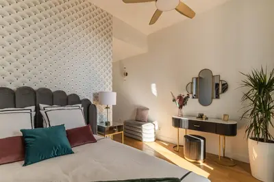 a bedroom with a large bed with a large headboard at The Gatsby room - 50m des halles - Design avec ascenseur in Narbonne