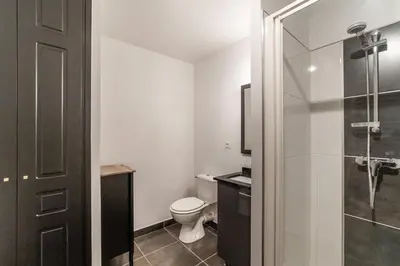 a bathroom with a toilet and a glass shower at The Gatsby room - 50m des halles - Design avec ascenseur in Narbonne