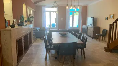 a dining room with a table and chairs and a fireplace at Logis de la Foulerie in Bize-Minervois