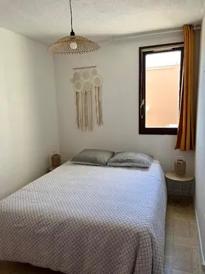 a bedroom with a bed and a window at Appartement T2 Gruissan port, rive gauche in Gruissan