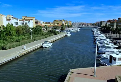 a river with boats docked next to a bridge at Appartement T2 Gruissan port, rive gauche in Gruissan