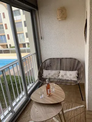a balcony with a table and a chair and a window at Appartement T2 Gruissan port, rive gauche in Gruissan