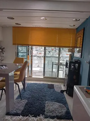 a living room with a dining room table and a table and chairs at Loc de cabines sur Yacht in Gruissan