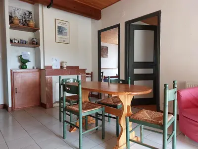 a dining room with a wooden table and chairs at La Ginelle - Appartement Terrasse in Airoux