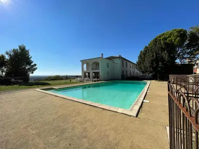 a swimming pool in front of a house at La Ginelle - Appartement Terrasse in Airoux