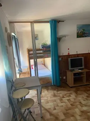 a room with a bedroom with a desk and a television at Studio Plage 200m Parking gratuit Port la Nouvelle in Port-la-Nouvelle