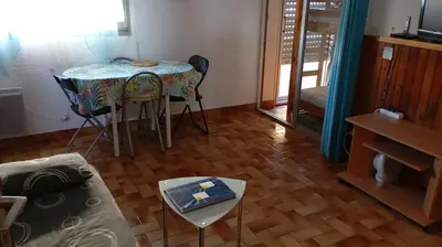 a living room with a table and a couch at Studio Plage 200m Parking gratuit Port la Nouvelle in Port-la-Nouvelle