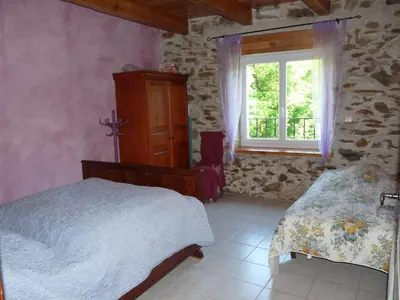 a bedroom with a bed and a window at Gîte LA FENIAL in Montredon-Labessonnié