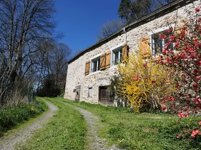 an old stone building with a dirt road next to it at Gîte LA FENIAL in Montredon-Labessonnié