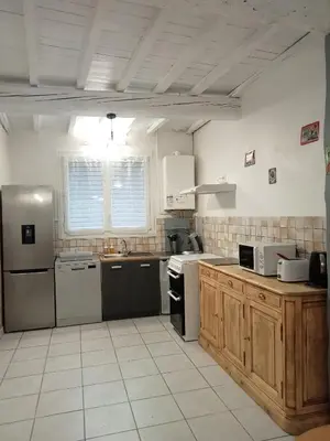 a kitchen with a stove and a refrigerator at Le Patio in Villegailhenc