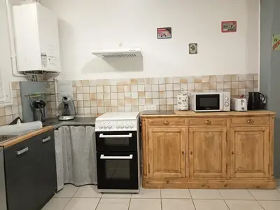 a kitchen with a stove and a microwave at Le Patio in Villegailhenc