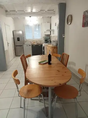 a wooden table and chairs in a kitchen at Le Patio in Villegailhenc