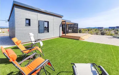 a group of chairs sitting on a lawn in front of a house at Gorgeous Home In Olonzac With Kitchen in Olonzac