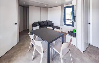 a dining room with a black table and white chairs at Gorgeous Home In Olonzac With Kitchen in Olonzac