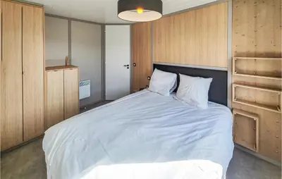 a bedroom with a large white bed with wooden cabinets at Gorgeous Home In Olonzac With Kitchen in Olonzac