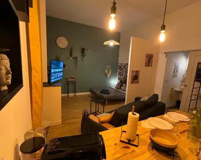 a living room with a table and a couch at Charmant appartement climatisé aux pieds de la cité in Carcassonne
