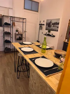 a table with plates and wine glasses on it at Charmant appartement climatisé aux pieds de la cité in Carcassonne
