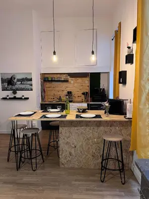 a kitchen with a counter and bar with stools at Charmant appartement climatisé aux pieds de la cité in Carcassonne