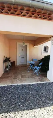 a patio with two chairs and a table in a building at La Bastide du Canal avec piscine et clim in Carcassonne