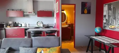 a living room with a couch and a kitchen at La Bastide du Canal avec piscine et clim in Carcassonne