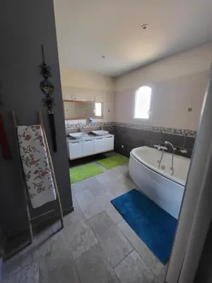 a bathroom with two sinks and a bath tub at La Bastide du Canal avec piscine et clim in Carcassonne