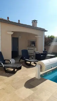 a patio with two chairs and a swimming pool at La Bastide du Canal avec piscine et clim in Carcassonne