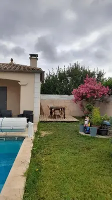 a backyard with a picnic table and a pool at La Bastide du Canal avec piscine et clim in Carcassonne