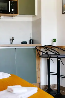 a kitchen with a table and a black chair at Studio avec parking vue sur la Cité de Carcassonne in Carcassonne