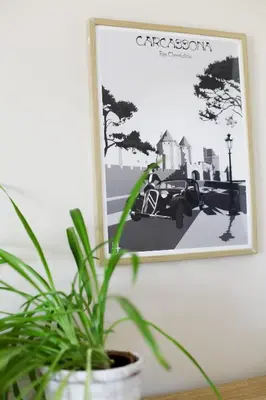 a plant sitting on a table next to a picture at Studio avec parking vue sur la Cité de Carcassonne in Carcassonne