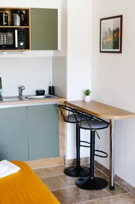 a kitchen with a wooden table and a sink at Studio avec parking vue sur la Cité de Carcassonne in Carcassonne