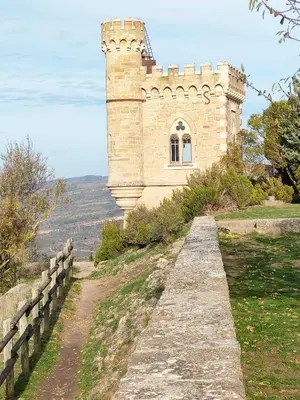 a building on top of a hill with a fence at Gîte chaleureux au cœur du village in Roquetaillade