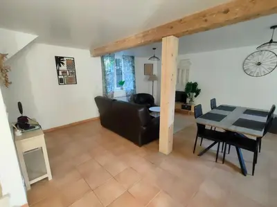 a living room with a table and a couch at Gîte chaleureux au cœur du village in Roquetaillade