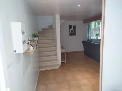a hallway with a staircase and a stair case at Gîte chaleureux au cœur du village in Roquetaillade