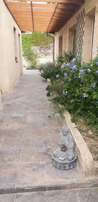 a patio with a statue on the side of a building at L'Annexe in Sigean